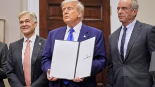 President Donald Trump, with Dr. Mehmet Oz, Administrator of the Centers for Medicare & Medicaid Services, left, and Health and Human Services Secretary Robert F. Kennedy Jr., right, holds an executive order related to drug prices, in the Roosevelt Room of the White House in Washington, Monday, May 12, 2025, in Washington.
