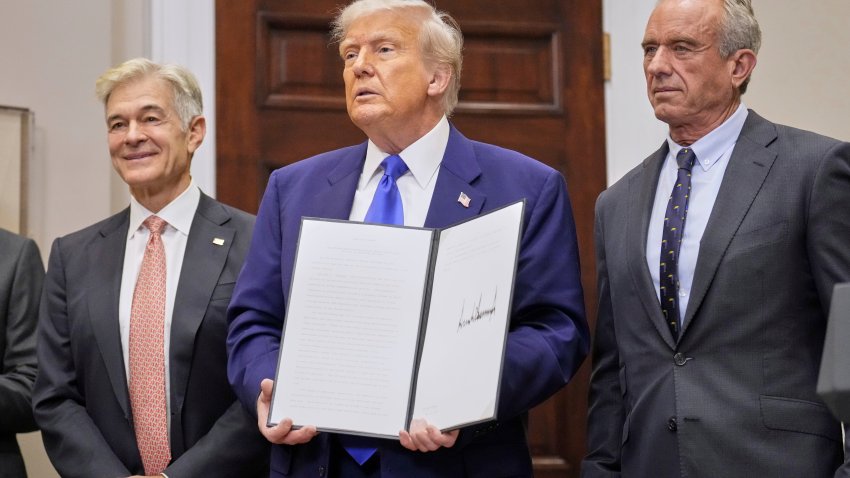 President Donald Trump, with Dr. Mehmet Oz, Administrator of the Centers for Medicare & Medicaid Services, left, and Health and Human Services Secretary Robert F. Kennedy Jr., right, holds an executive order related to drug prices, in the Roosevelt Room of the White House in Washington, Monday, May 12, 2025, in Washington.