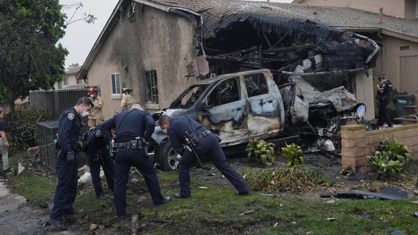 Authorities work the scene where a small plane crashed into a San Diego neighborhood, setting several homes on fire and forcing evacuations along several blocks early Thursday, May 22, 2025. (AP Photo/Gregory Bull)