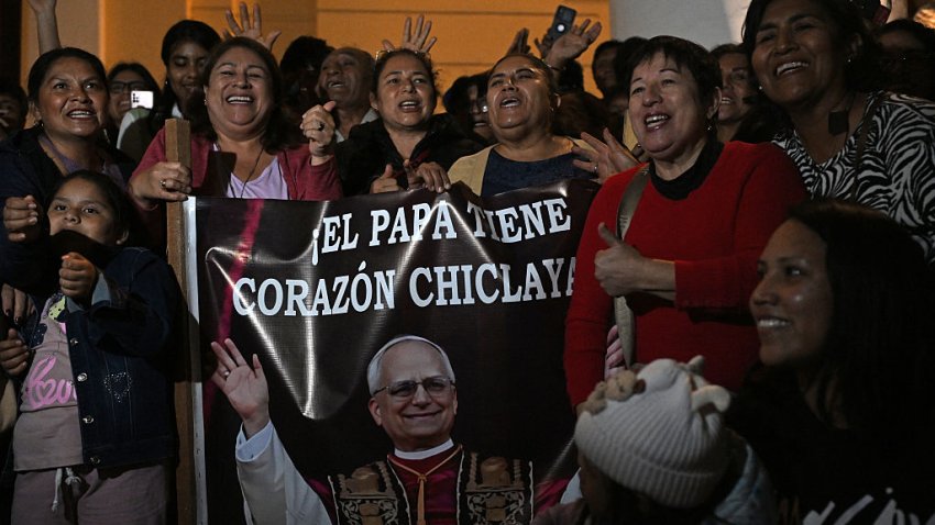 People pose next to the image of Robert Francis Prevost, who became Pope Leo XIV on May 8, 2025, in front of the cathedral of Chiclayo in northern Peru on the day of his election as the Catholic Church’s 267th pontiff. The US-born pontiff, close to Pope Francis, became a Peruvian national in 2015 and devoted more than 20 years as a missionary in Peru. (Photo by ERNESTO BENAVIDES / AFP) (Photo by ERNESTO BENAVIDES/AFP via Getty Images)