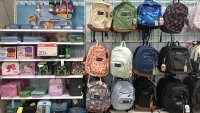 A variety of school supplies, including lunch boxes and backpacks in different colors and patterns, are on display for the upcoming school year.