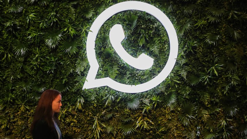 A woman walks past a logo of WhatsApp, during a Meta event in Mumbai, India, 20 September, 2023. 