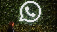A woman walks past a logo of WhatsApp during a Meta event in Mumbai, India, on Sept. 20, 2023.