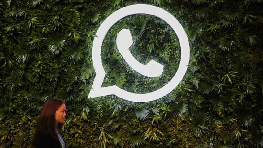 A woman walks past a logo of WhatsApp during a Meta event in Mumbai, India, on Sept. 20, 2023.