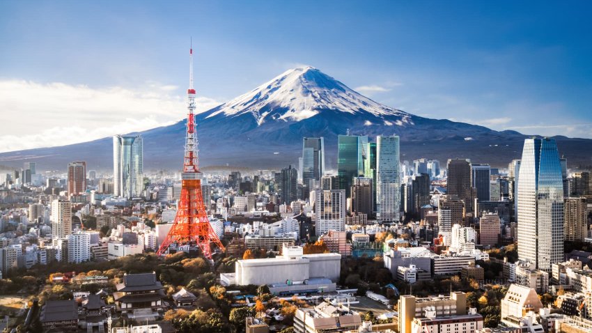 Aerial view of Mt. Fuji, Tokyo Tower and modern skyscrapers in Tokyo on a sunny day.
