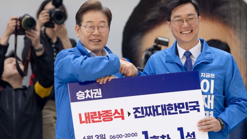 Lee Jae-myung, the presidential candidate of the Democratic Party of Korea, poses for a photo after receiving a symbolic ticket for the ”Lee Jae-myung Train” from lawmaker Jang Kyung-tae during a campaign rally at Yongsan Station Plaza in Seoul, South Korea, on May 19, 2025. (Photo by Chris Jung/NurPhoto via Getty Images)