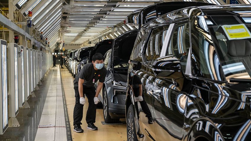 A worker checks a finished vehicle on the production line for electric vehicle maker Zeekr at its factory on May 29, 2025 in Ningbo, China.