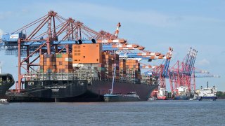 Cargo shipping containers are loaded with cranes on container ships at the Burchardkai container terminal at the harbour of Hamburg, northern Germany, on June 3, 2025.