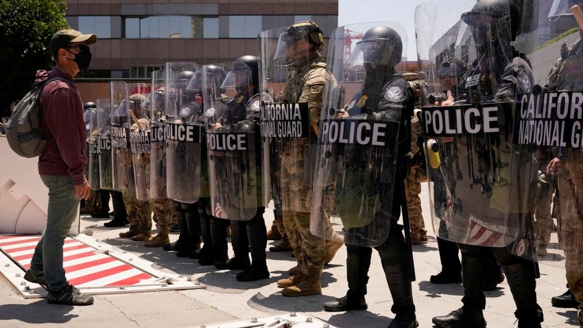 A man faces members of security forces outside the Edward R. Roybal Federal building after days of protests against federal immigration sweeps and the deployment of the California National Guard and U.S. Marines, in downtown Los Angeles, California, U.S., June 10, 2025.