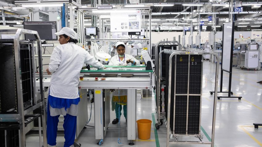 Employees work on an assembly line in a mobile phone plant in Tamil Nadu, India, on July 12, 2019.
