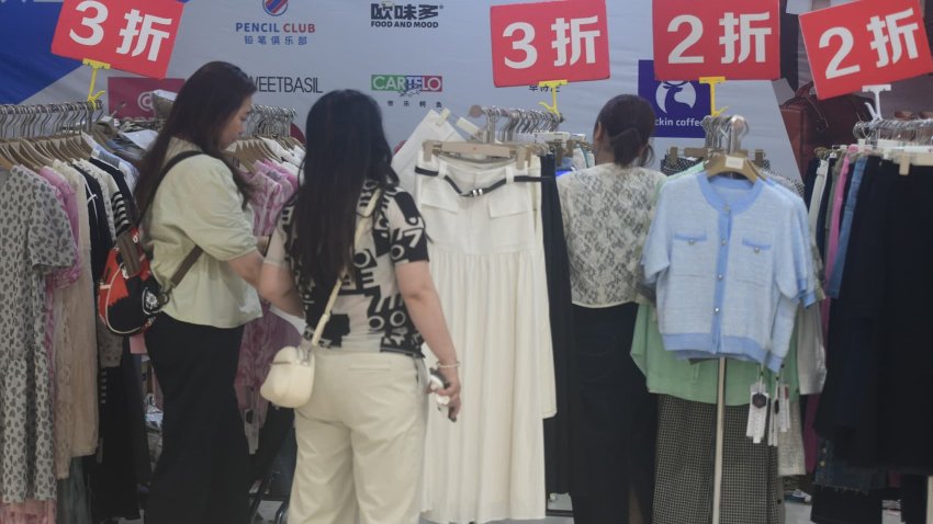 Customers look at clothes advertising discounts of 80% or 70% in a supermarket in Hangzhou, Zhejiang province, China, on June 9, 2025.
