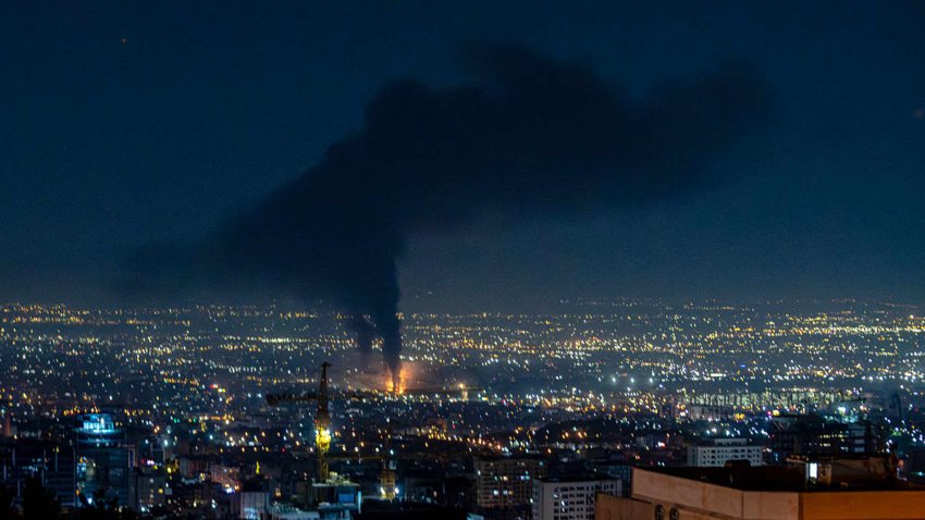 Smoke rises in the distance following an Israeli airstrike in Tehran, Iran, on June 14, 2025.