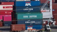 A truck passes by shipping containers at the Port of Los Angeles.