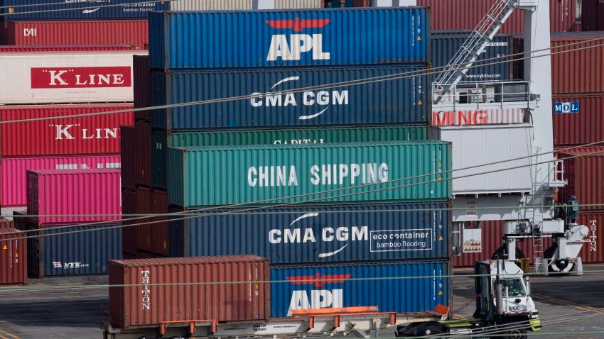 A truck passes by shipping containers at the Port of Los Angeles.