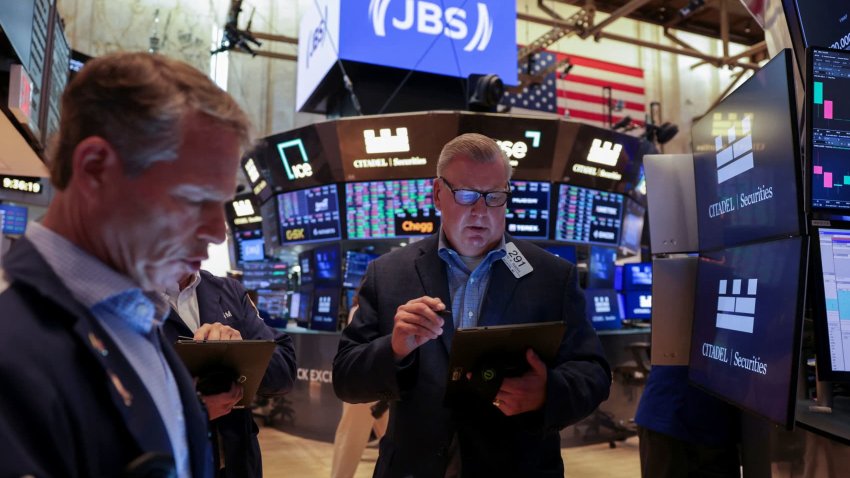 Traders work on the floor at the New York Stock Exchange (NYSE) in New York City, U.S., June 25, 2025.