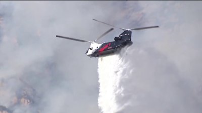 Firefighters getting support from above to battle flames in remote terrain