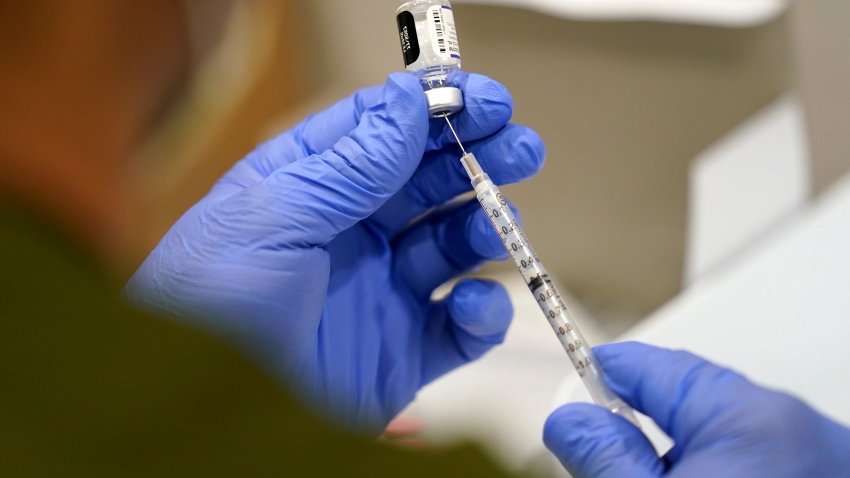 FILE – A healthcare worker fills a syringe with the Pfizer COVID-19 vaccine at Jackson Memorial Hospital on Oct. 5, 2021, in Miami.