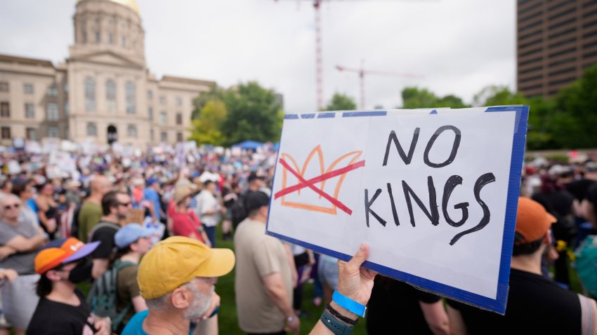 A demonstrator holds a sign during a "No Kings" protest
