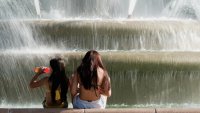 Two girls sitting at the fountain.