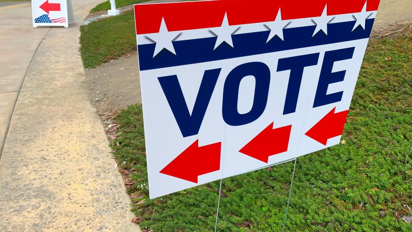 Red, white and blue sign with an arrow indicating where to go to vote.