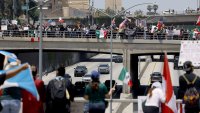 Protesters wave flags on the overpass of highway 101 during the "No Kings" demonstration in downtown Los Angeles .