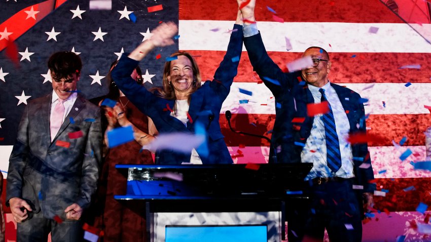 EAST BRUNSWICK, NEW JERSEY – NOVEMBER 04: New Jersey Democratic gubernatorial candidate, Rep. Mikie Sherrill (D-NJ) (C) celebrates with lieutenant gubernatorial candidate Dale Caldwell (R) after their win during an election night watch party at the Hilton East Brunswick Hotel on November 4, 2025 in East Brunswick, New Jersey. Sherrill defeated Republican assembly member Jack Ciattarelli in a tightly contested race for New Jersey governor.