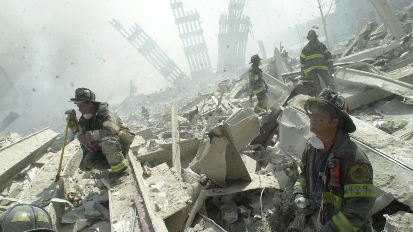 UNITED STATES &#8211; SEPTEMBER 11:  Firefighters search through the rubble of the World Trade Center after it was struck by a commercial airliner in a terrorist attack. A hijacked American Airlines Boeing 767, originating from Boston&#8217;s Logan Airport, struck 1 World Trade Center (north tower) at 8:45 a.m. At 9:03 a.m., a United Airlines 767, also hijacked in Boston, crashed into 2 World Trade Center (south tower).The second tower came down 39 minutes after the first.