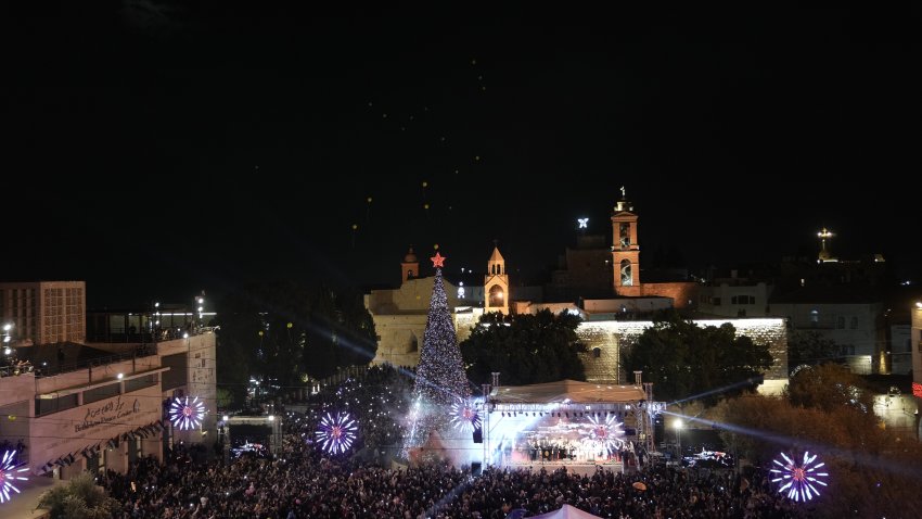 Palestinians take part in a Christmas tree–lighting event in Manger Square, next to the Church of the Nativity, traditionally regarded as the birthplace of Jesus Christ ahead of Christmas in the West Bank city of Bethlehem Saturday, Dec. 6, 2025.