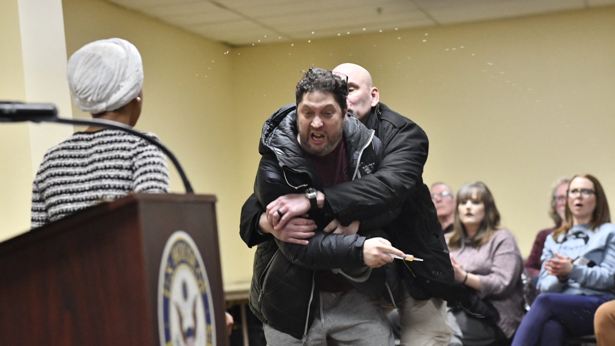 A man was tackled to the ground after spraying an unknown substance on U.S. Rep. Ilhan Omar at a town hall she was hosting in Minneapolis.