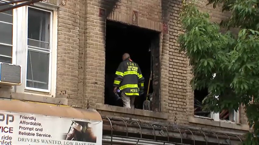Firefighters comb through the scene after a fire claimed two lives Saturday in Flatbush, Brooklyn.