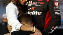 Kyle Busch embraces his wife, Samantha, and son, Brexton, prior to a race in 2022.