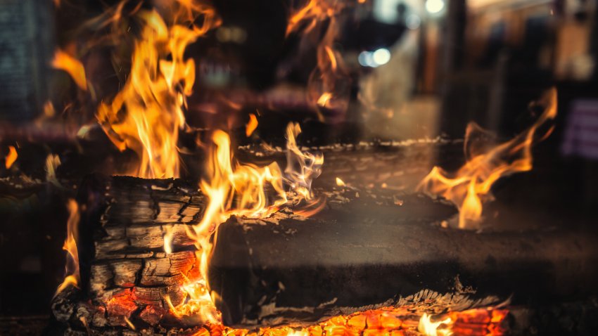Detail of a transparent home fireplace with burning wood.