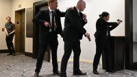TOPSHOT – Agents draw their guns after loud bangs were heard during the White House Correspondents’ dinner at the Washington Hilton in Washington, DC, on April 25, 2026. President Trump is attending the annual gala of the political press for the first time while in office. (Photo by Mandel NGAN / AFP via Getty Images)
