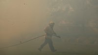 FILE – A firefighter works as the Sandy Fire approaches May 19, 2026, in Simi Valley, Calif.