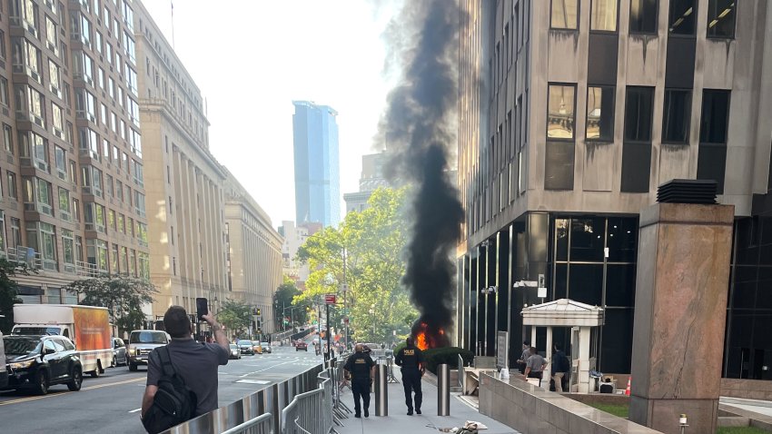 This photo provided by Robert Sullivan shows black smoke and flames in front of 26 Federal Plaza in lower Manhattan, Monday, July 20, 2026, in New York.