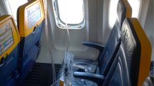 This undated photo provided by the National Transportation Safety Board on Thursday, Aug. 13, 2026, shows the shattered window on a Ryanair plane that was broken by a stray engine part shortly after takeoff, causing a man's head to be sucked into the hole. 