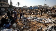 Displaced Palestinians inspect the destruction following an Israeli airstrike that targeted the nearby medical supplies and pharmaceuticals warehouse of Al-Aqsa Martyrs Hospital, in Deir al-Balah, central Gaza Strip on August 1, 2026. Hamas said on July 31, 2026, it had agreed to a deal that includes handing over its weapons to a Palestinian governing committee and the gradual withdrawal of Israeli forces from the Gaza Strip. Israel has yet to officially comment on the announcement. (Photo by Majdi Fathi/NurPhoto via Getty Images)