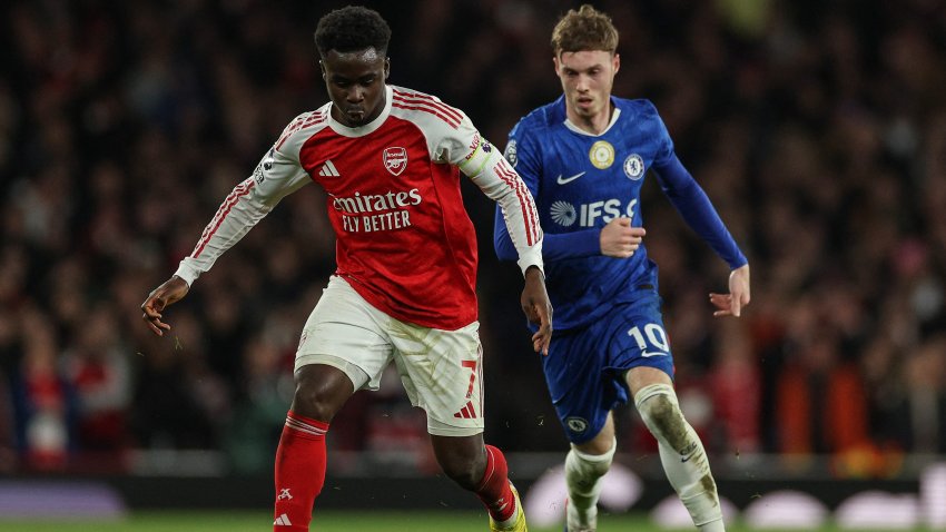 Arsenal's English midfielder #07 Bukayo Saka (L) is challenged by Chelsea's English midfielder #10 Cole Palmer (R).