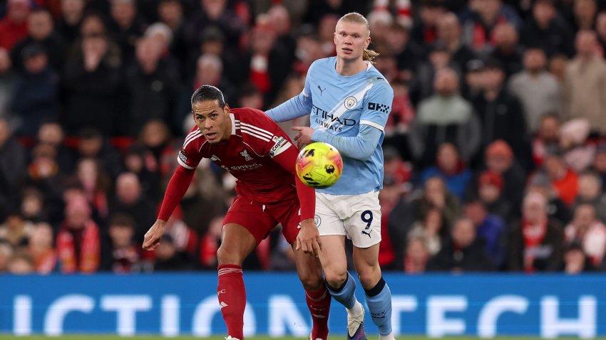 Virgil van Dijk of Liverpool battles for possession with Erling Haaland of Manchester City.